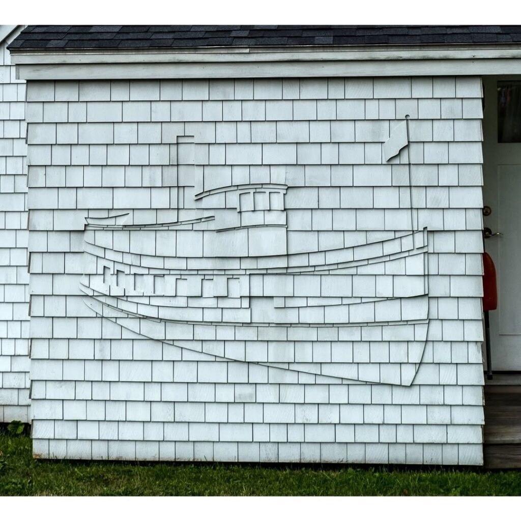handcrafted cedar shingles forming sailboat design on siding