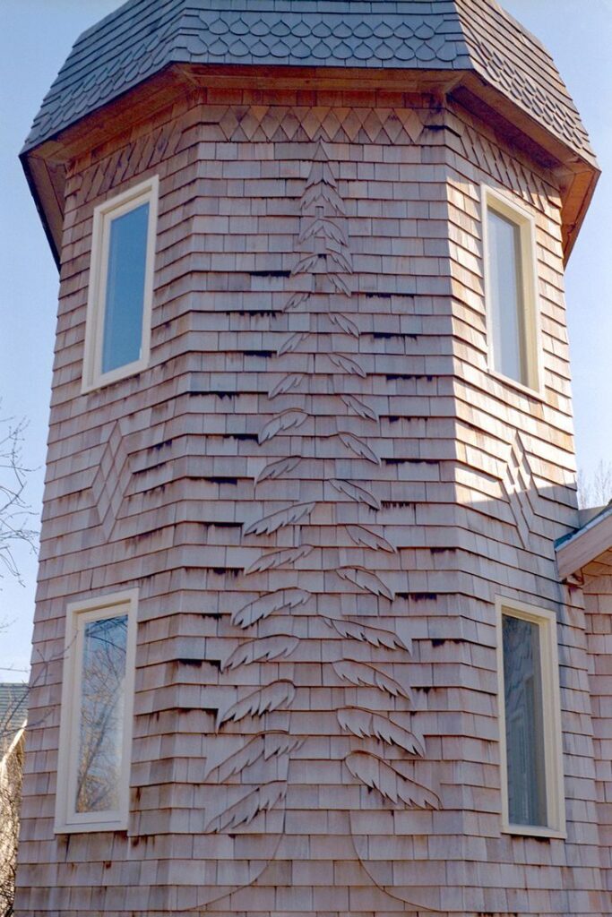 carved cedar tree design by Jim McNeil on wood shingle wall