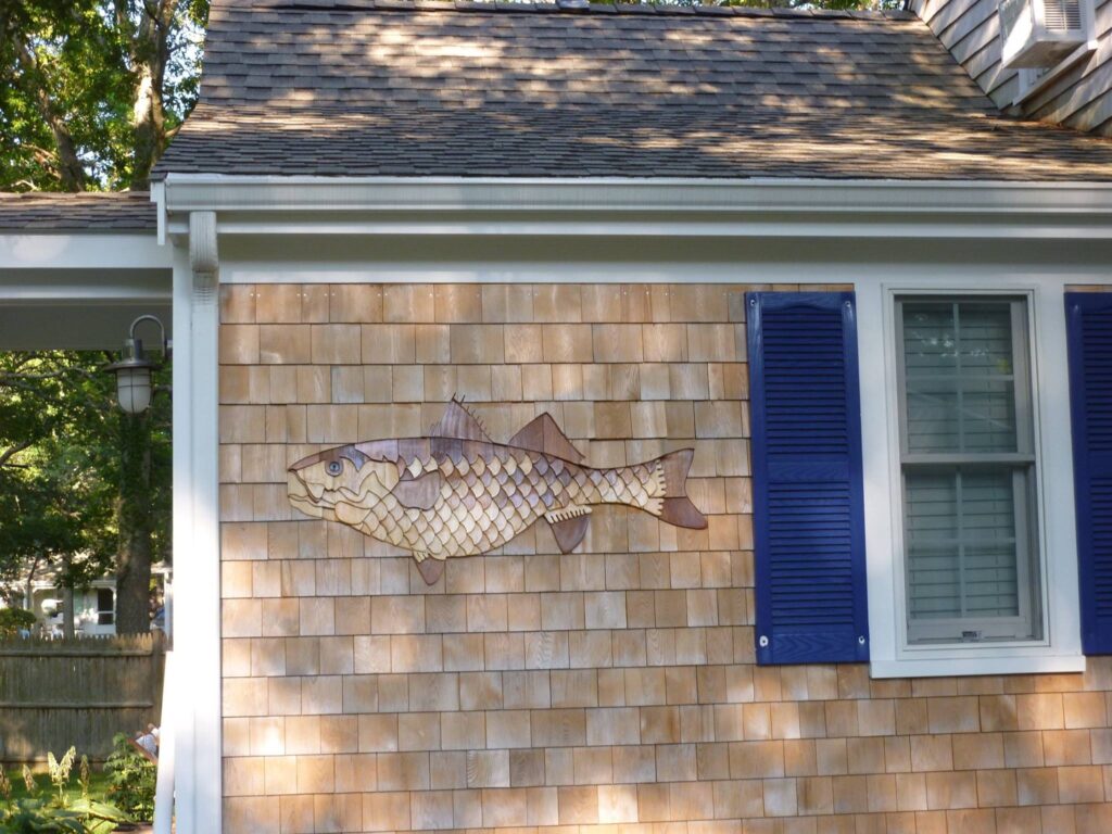 cedar shingle wall featuring detailed fish design by Roger Dumas