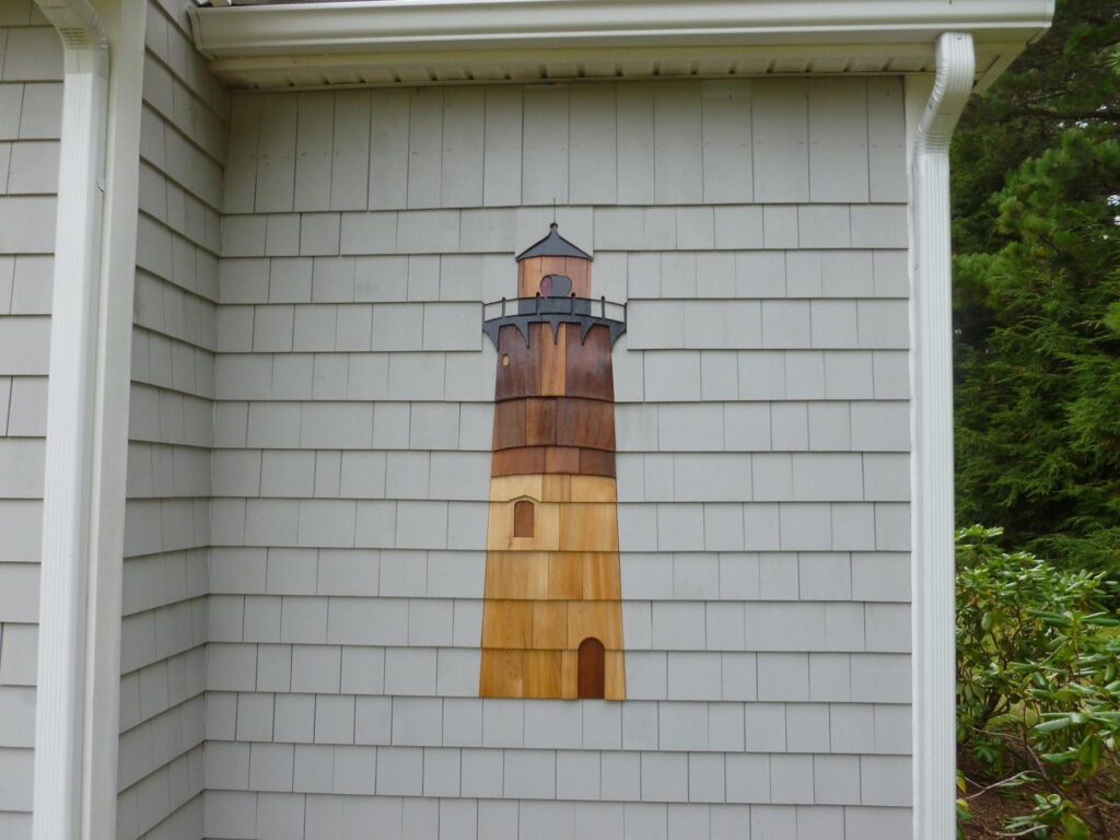 lighthouse artwork formed from cedar shingles on exterior wall