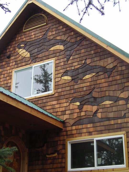 decorative cedar shingle mural depicting whales on inn facade