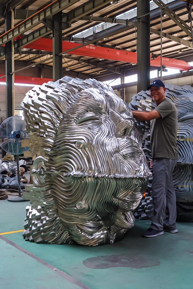 Gil Bruvel and his woman head sculpture made from metal, that looks like a reflection