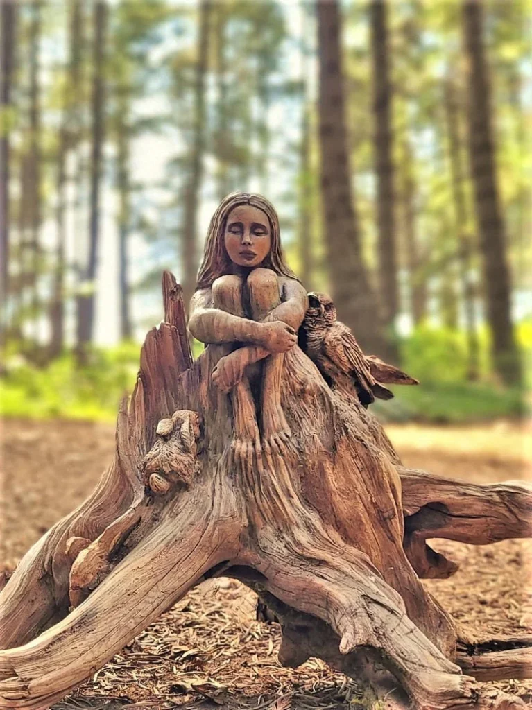 woman sitting on root carved sculpture